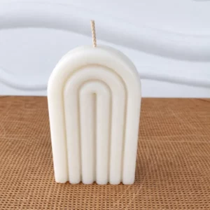 Bougie blanche en forme d'arche posée sur un table en bois