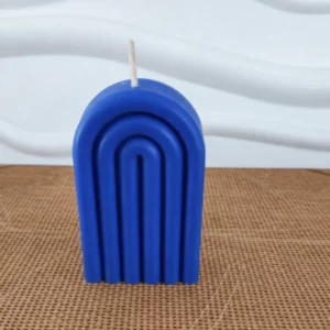 Bougie bleue en forme d'arche posée sur un table en bois