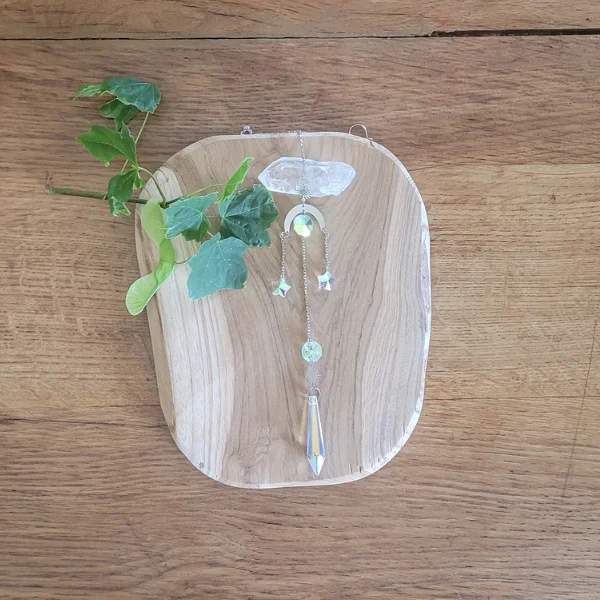 attrape soleil avec une lune et 2 pendentifs étoiles . Présenté sur une rondelle de bois et avec un cristal de roche.