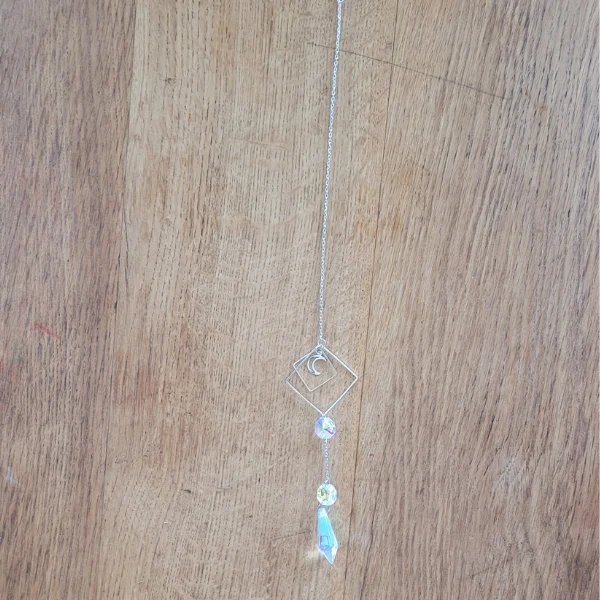 attrape soleil avec pendentif lune dans un carré. sur un fond en bois