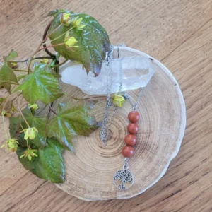 collier avec 4 perles de jaspe rouge et un pendentif en acier argenté arbre de vie. Sur une rondelle de bois