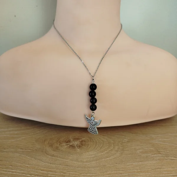 collier avec 4 perles obsidienne de 28 cm avec au bout pendentif ange en acier argenté. Sur rondelle de bois