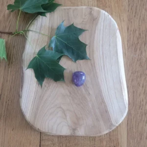 pierre roulée améthyste sur du bois avec feuille verte en decoration